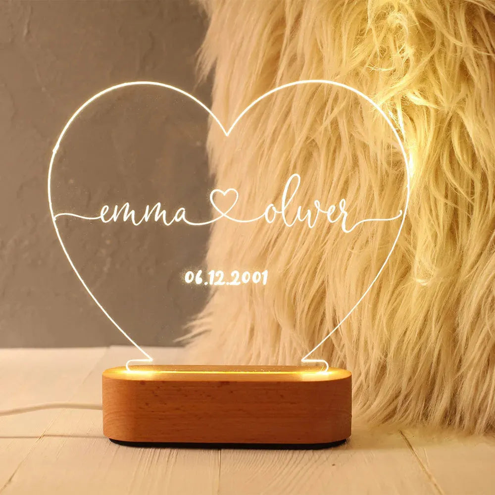 Custom transparent acrylic night light showing personalised names and date, lit by an LED base.