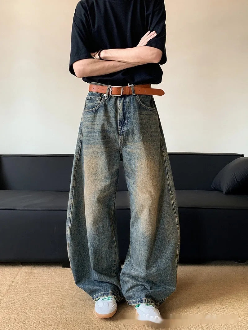 Men's retro blue distressed denim jeans with slim fit wide leg design showing machete wash detailing