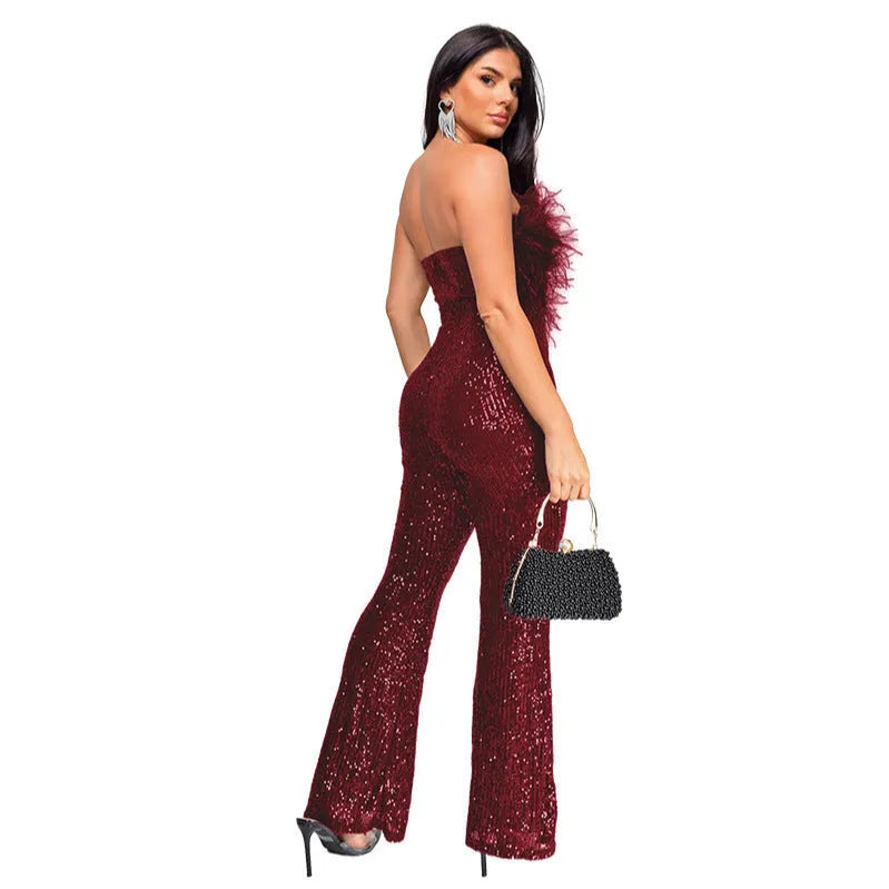 A woman wearing a black sleeveless backless jumpsuit with flared legs and sequin embellishments.