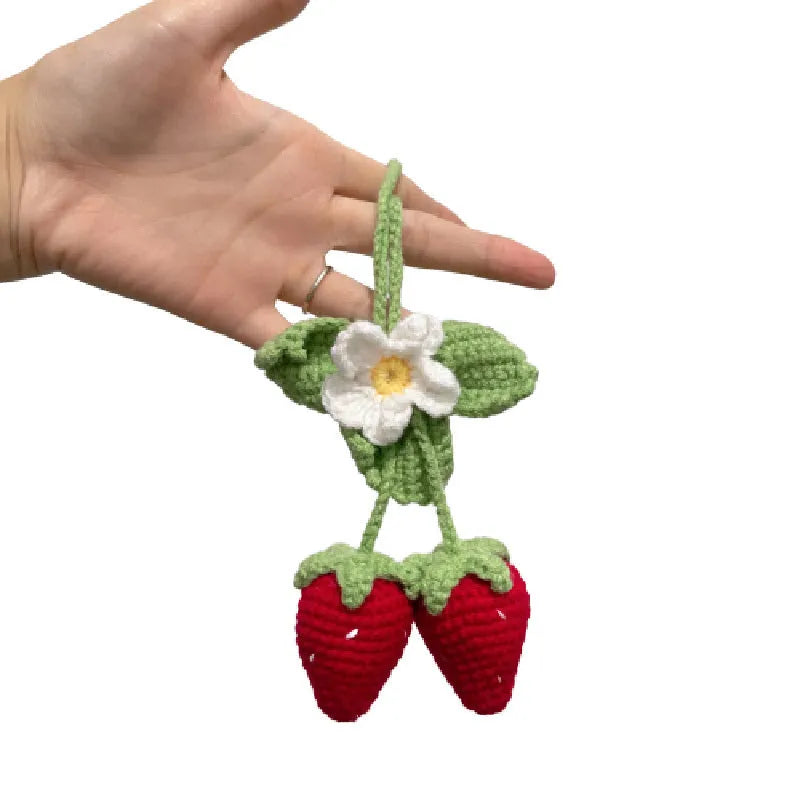 Handmade strawberry-shaped car pendant woven from cotton and hemp wool, hanging as a decorative accessory.