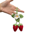 Handmade strawberry-shaped car pendant woven from cotton and hemp wool, hanging as a decorative accessory.
