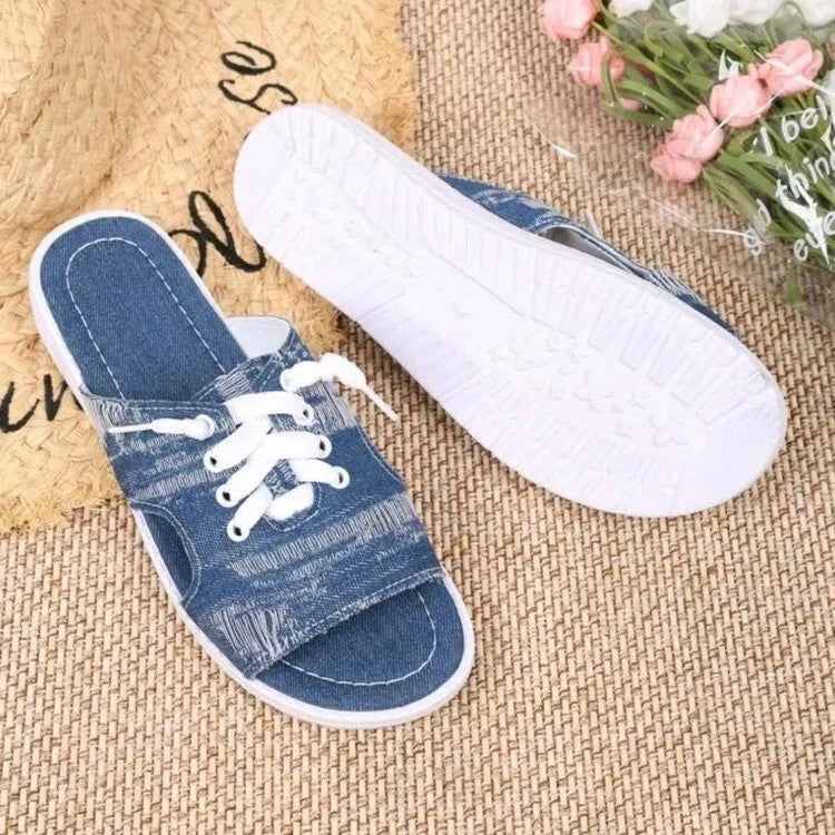 Blue Roman style women's flat canvas slippers with a rubber sole on a plain background.