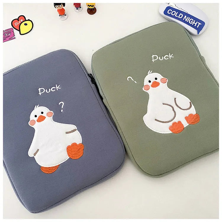 Blue cotton tablet case with embroidered cartoon duck design and a zipper, shown next to a green version.