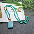 Turquoise hand-woven mesh flower lucky pendant on a long, adjustable ball bead necklace chain.