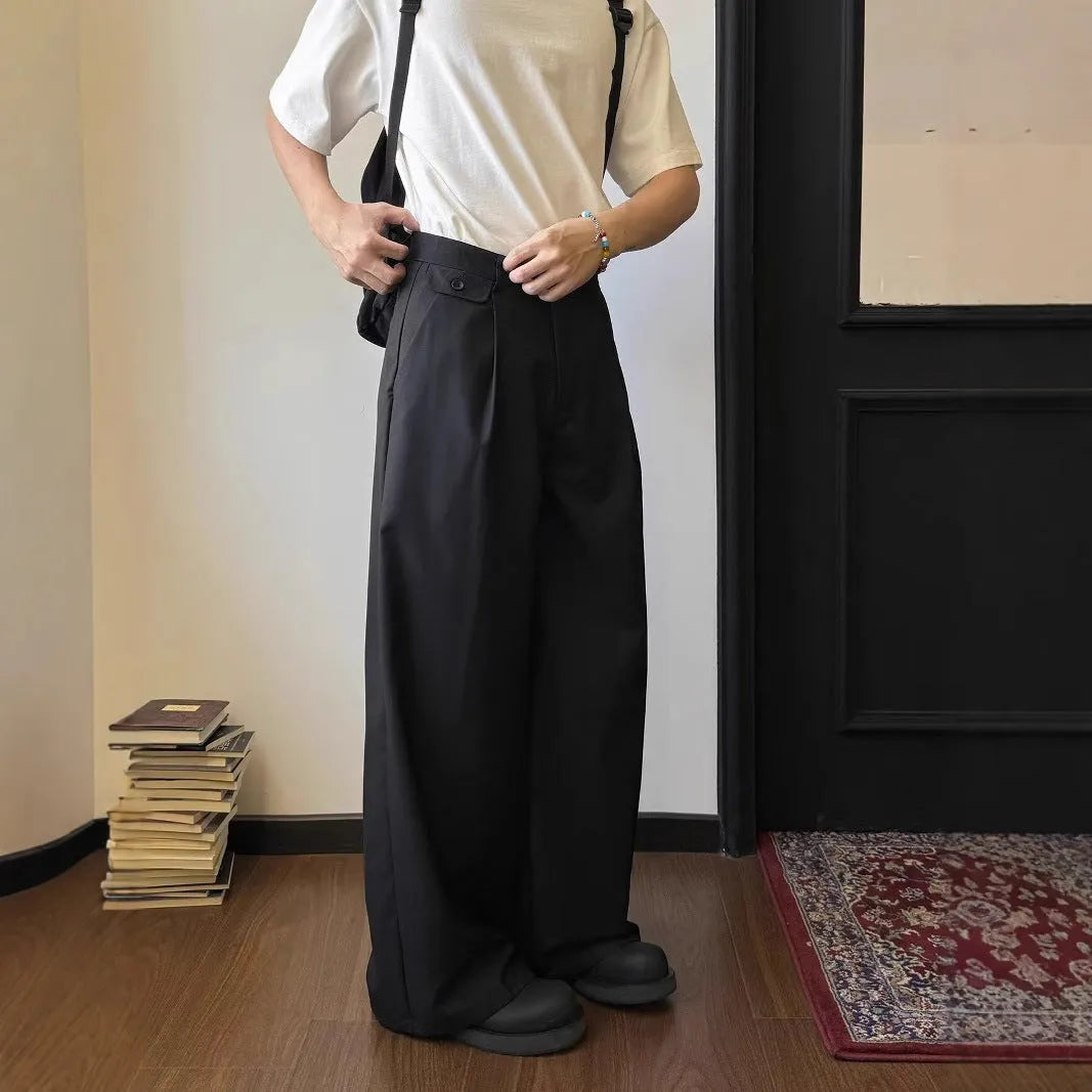 Man wearing solid colour straight-leg casual suit trousers with a loose wide-leg draping fit.