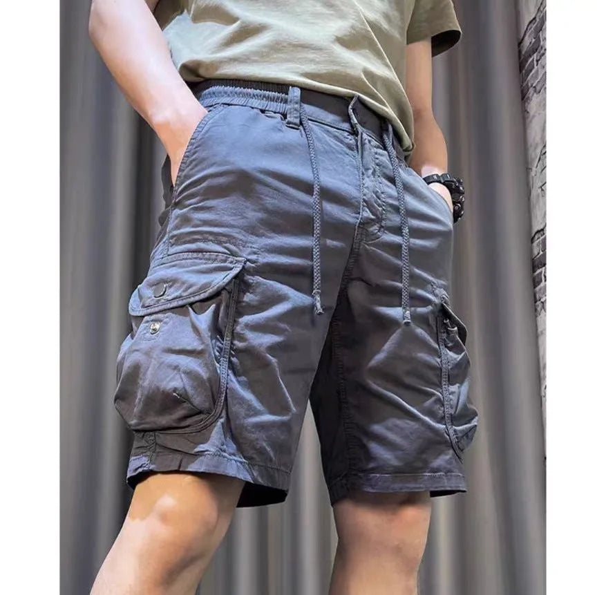 A model wearing loose, straight-leg multi-pocket casual overalls in a khaki colour.
