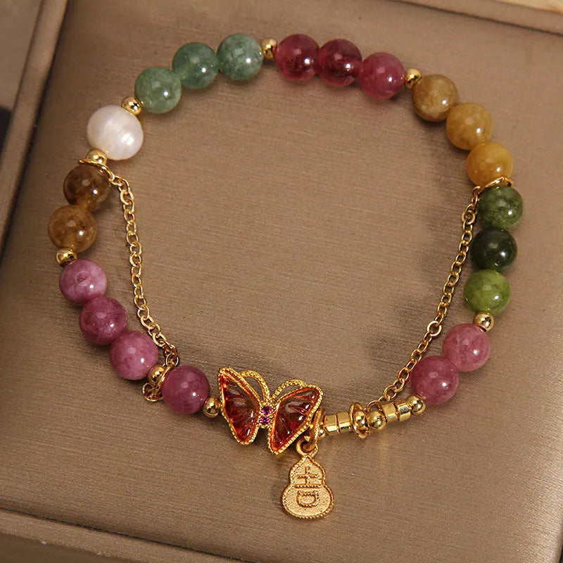 Close-up of a women's agate bracelet with a jade green tourmaline butterfly gourd bead.