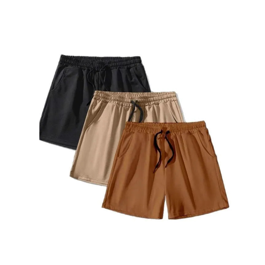 A pack of three men's solid colour drawstring shorts in black, khaki, and light brown, laid flat.