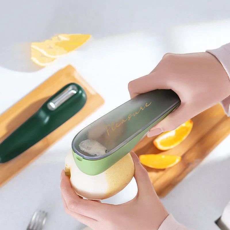 Dark green vegetable peeler with stainless steel blade stored inside a transparent plastic tube.