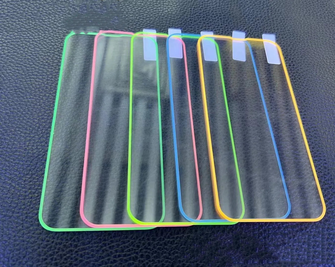 Fluorescent tempered glass full cover screen protector for iPhone in pink, yellow, green, blue, and grass green colours.