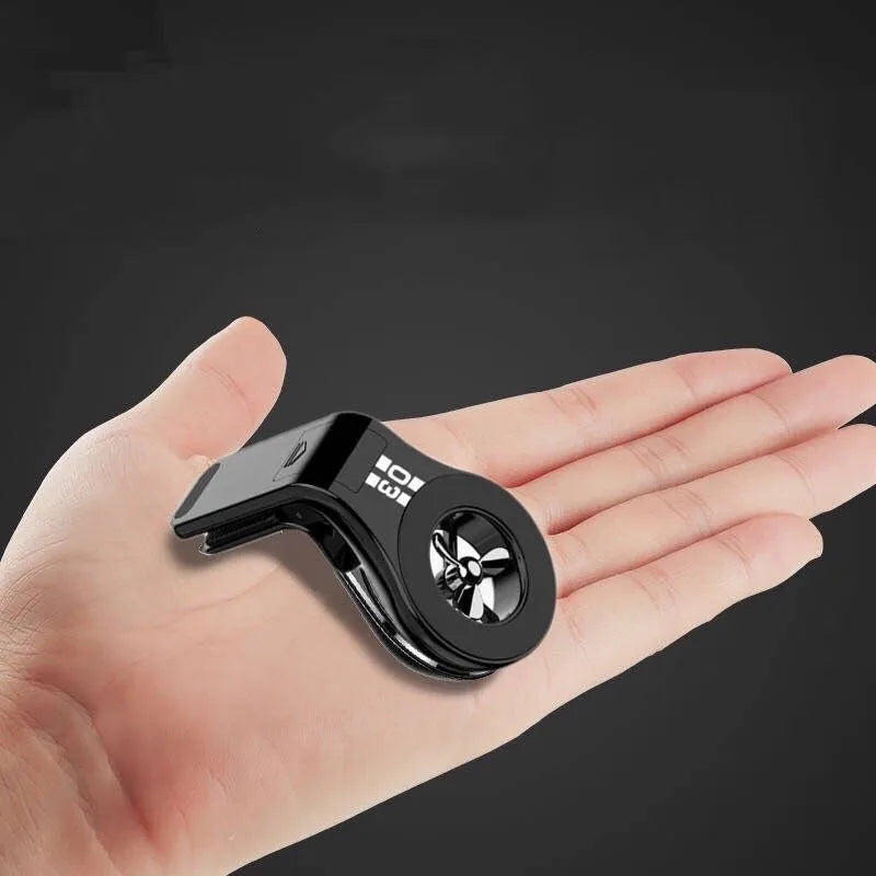 Black magnetic car phone holder with perfume slices, clipped on a car air vent