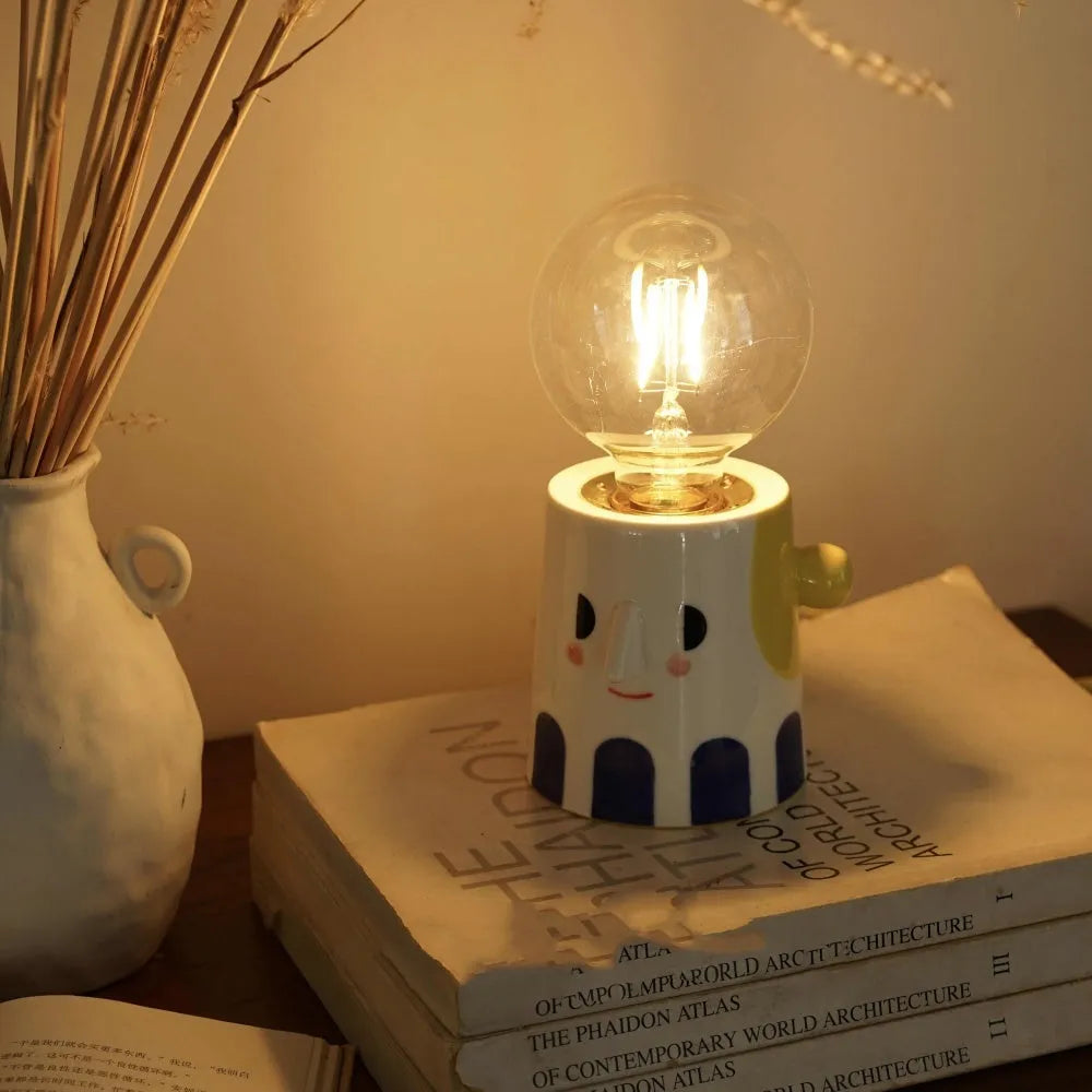 Handmade ceramic bedside lamp with a ball headlight colour finish on a table.