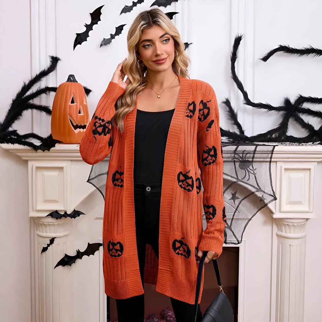 Women's black Halloween cardigan with orange pumpkin head jacquard pattern, shown as a medium-length knitted coat.