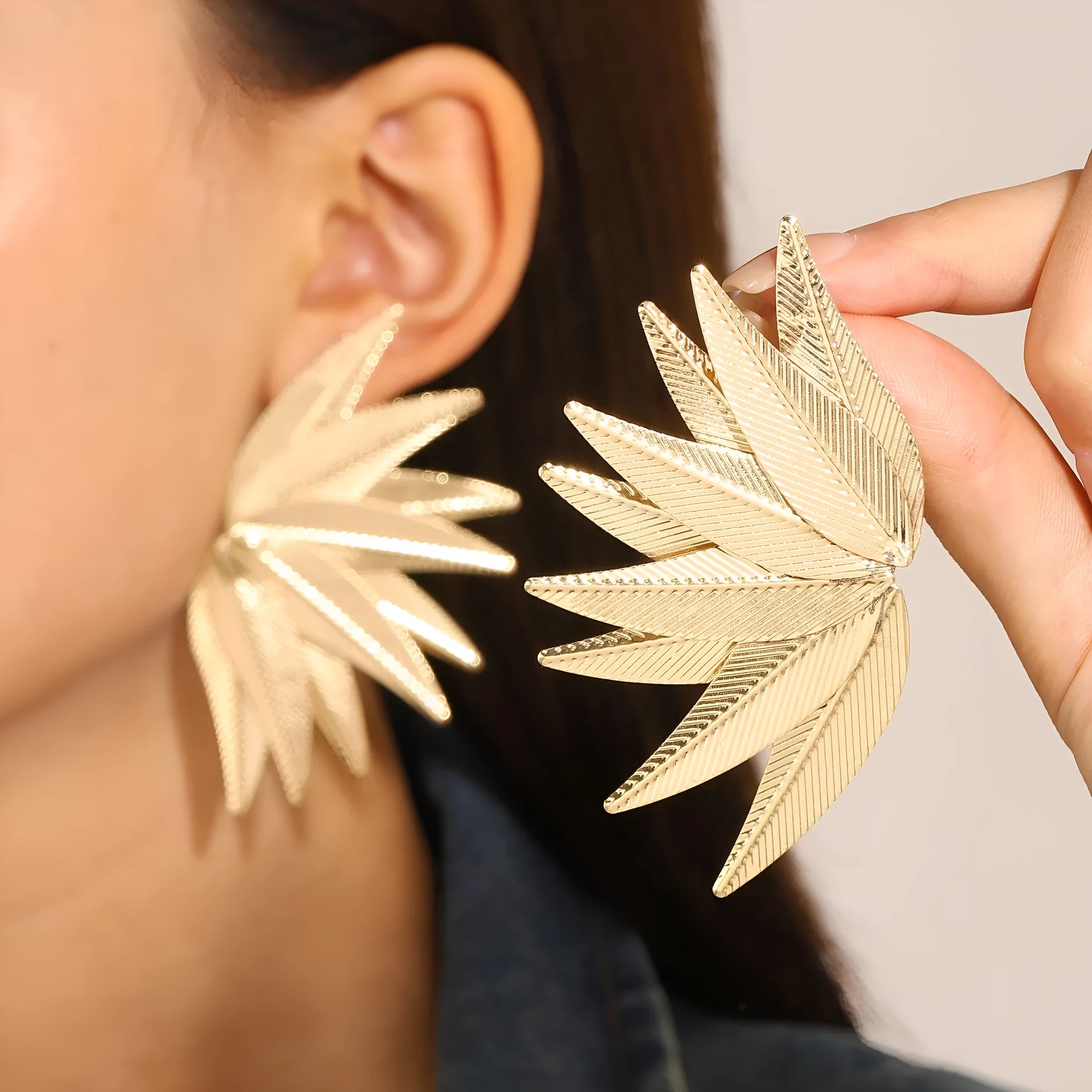 Gold and white leaf-shaped alloy patch earrings showing botanical design