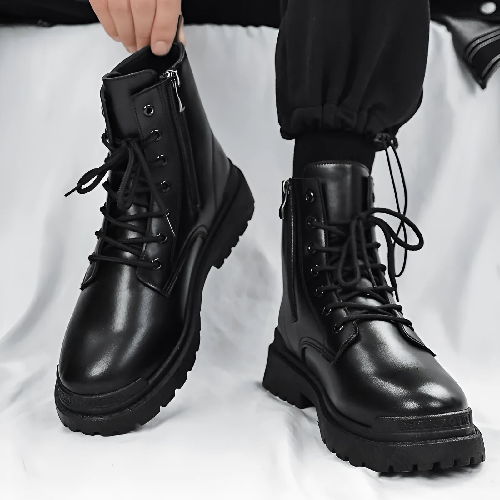 Men's black mid-top PU boots with a flat rubber sole, shown on a white background.