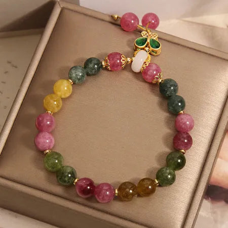 Women's bracelet with natural jade colour tourmaline butterfly pendant and rhinestone accents on alloy setting.