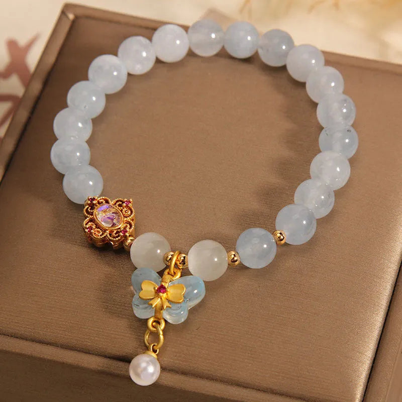 Aquamarine butterfly pendant crystal bracelet for women with rhinestone details on silver chain.