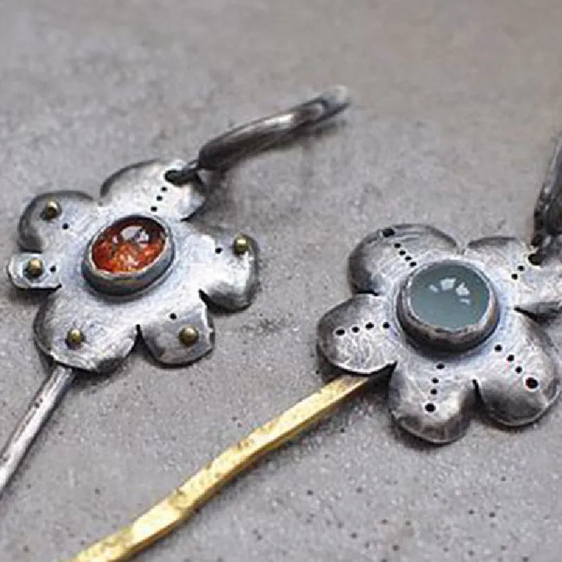 Geometric floral retro earrings with two-tone asymmetrical design and long drop style.