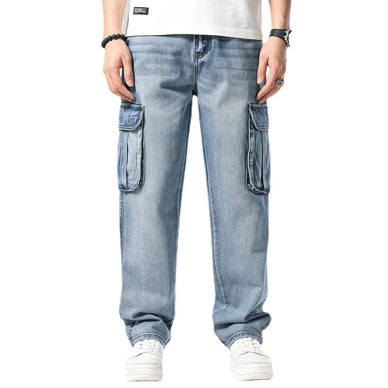 Man wearing loose-fit blue denim hip hop trousers with multiple pockets and a straight leg.