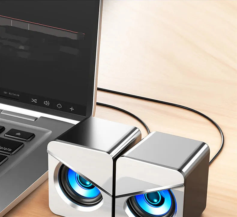Black and white USB wired desktop computer speakers with volume knob on compact plastic housing.