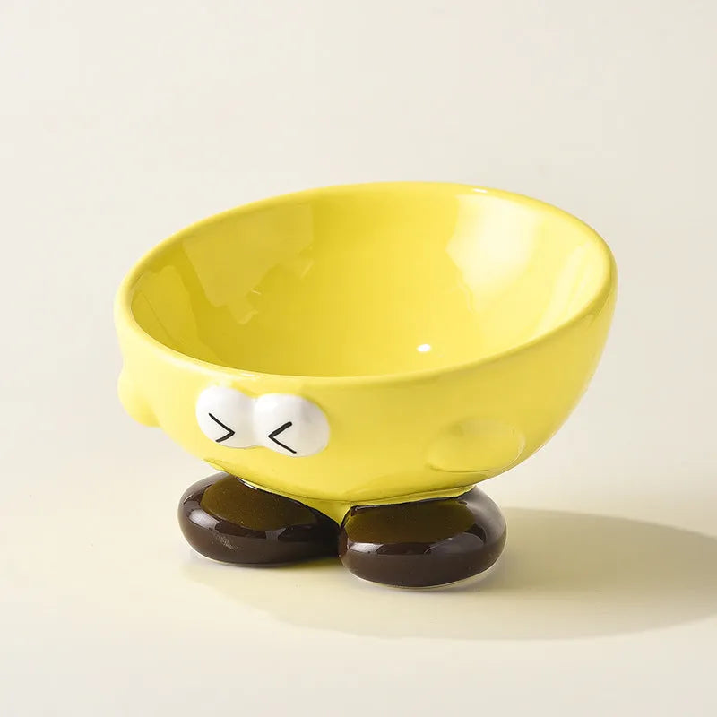 Blue and yellow ceramic slanted pet food bowls with animal face expressions for cervical spine support.