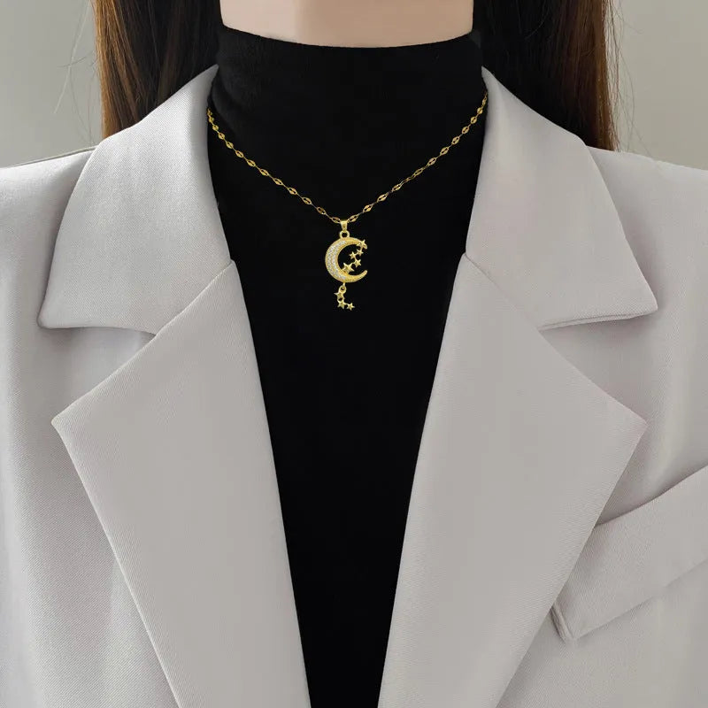 Stainless steel necklace with diamond-covered moon geometric pendant and tassel detail.