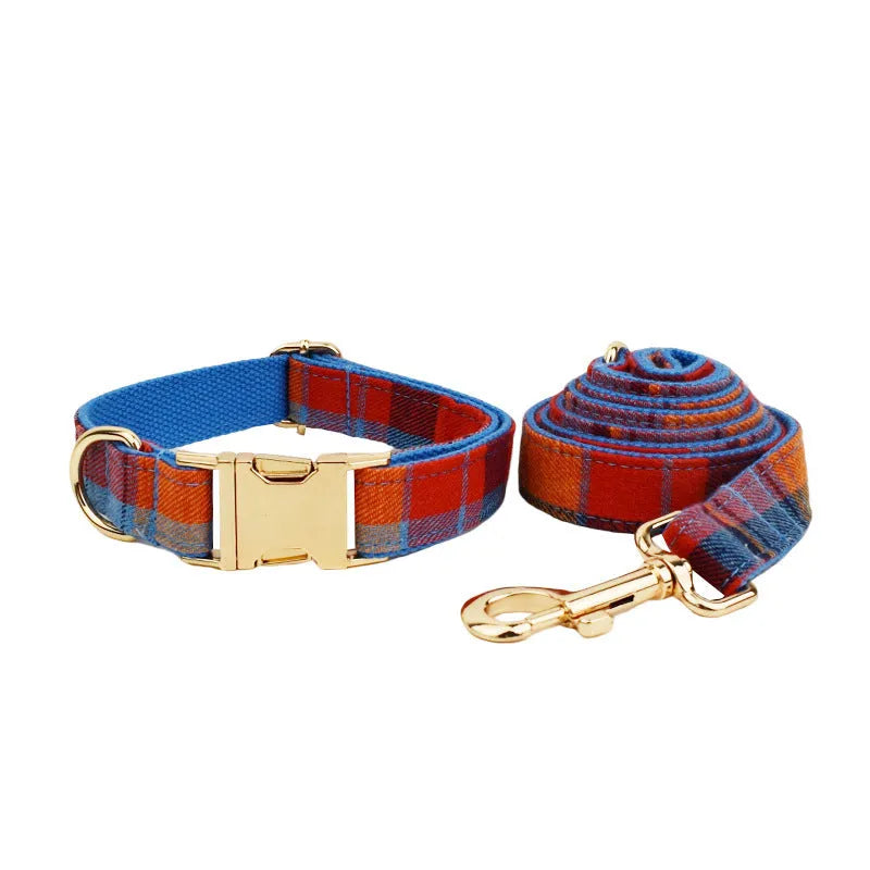 Blue background velvet plaid dog collar and matching hand holding leash on a white surface.