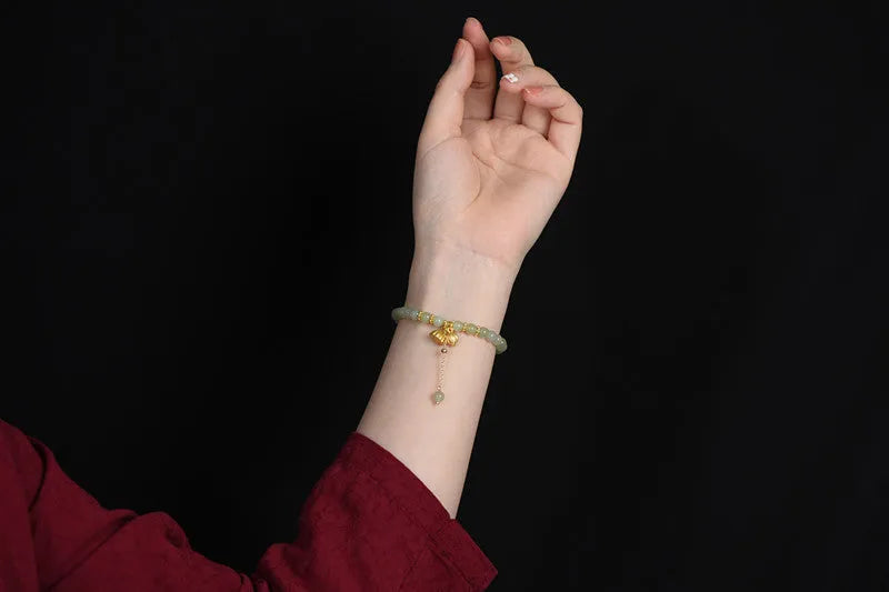 Natural Hetian jade bracelet with a carved Fu character charm on a wrist.