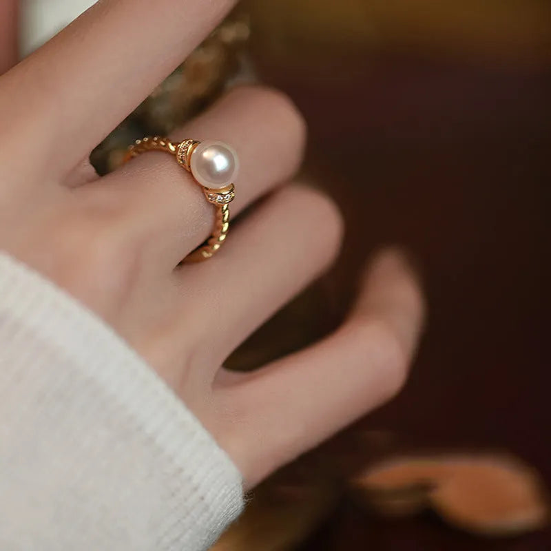 Adjustable antique twist copper ring with an inlaid pearl in gold colour.