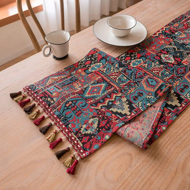 Nordic jacquard bouquet pattern table runner with tassel trim in dark blue on a dining table.