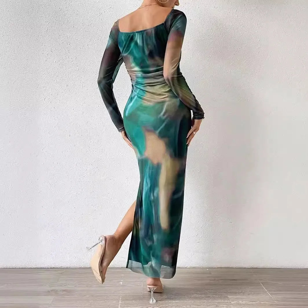 A long green mesh fishtail dress with a square collar, pleated detail, gradient colour, and a split hem.