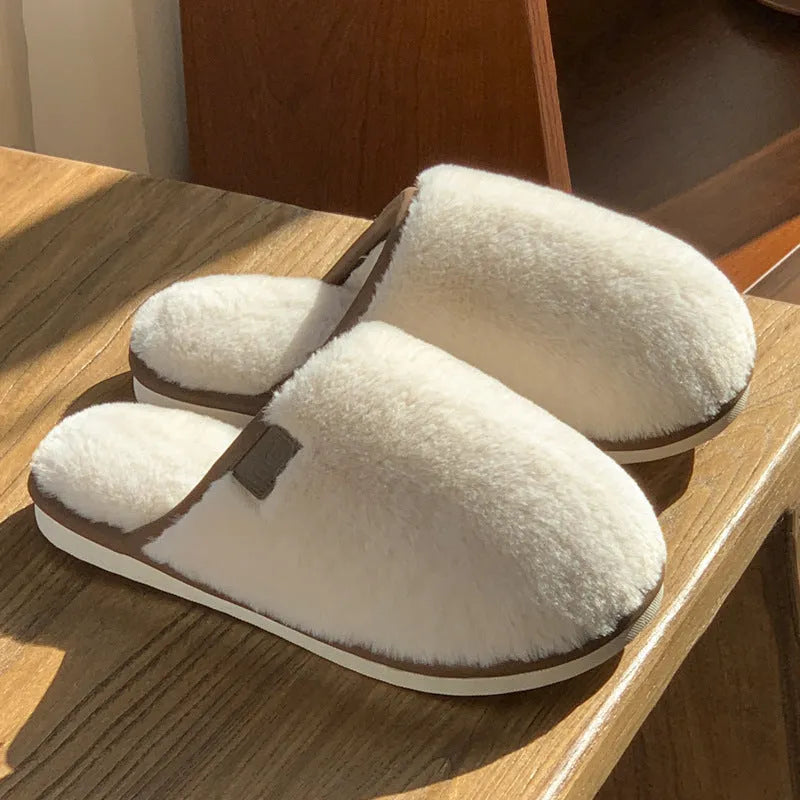Blue winter plush slippers with non-slip PVC soles on a wooden floor.
