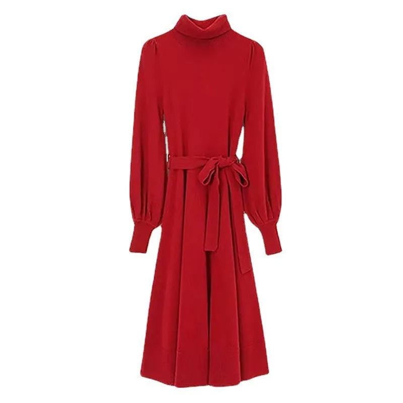 A woman wearing a rose red knitted turtleneck dress with a loose midi skirt and long sleeves.