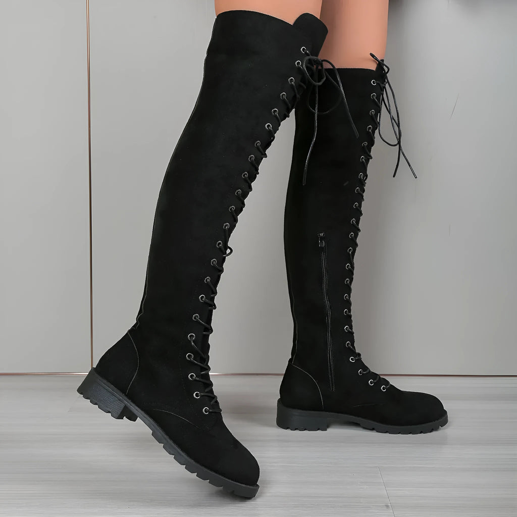 Women's black lace-up over-the-knee boots with a flat rubber sole and stitching detail.