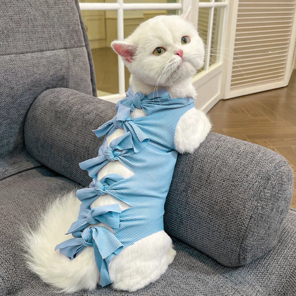 Lace-up cat sterilisation clothing in pink on a cat, showing the adjustable ties and full-body coverage.