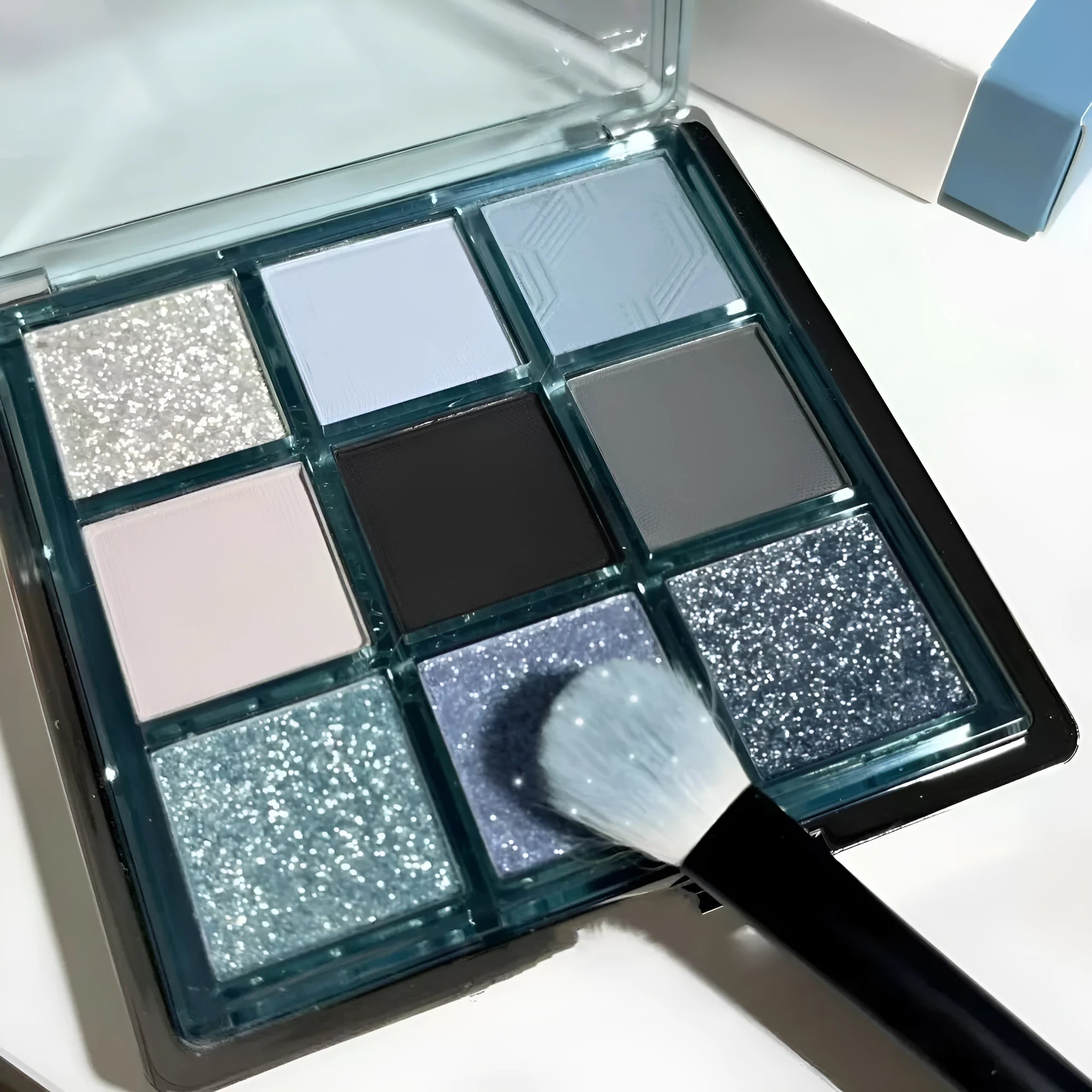 MUGELEEN nine-colour eye shadow palette open showing low saturation blue and complementary shades