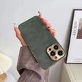 Leather texture solid colour phone case for iPhone on a table, showing black, blue, grey, and grey-green colour options.