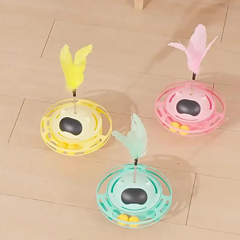Pink cat tumbler turntable toy with a colourful baton on a flat surface.