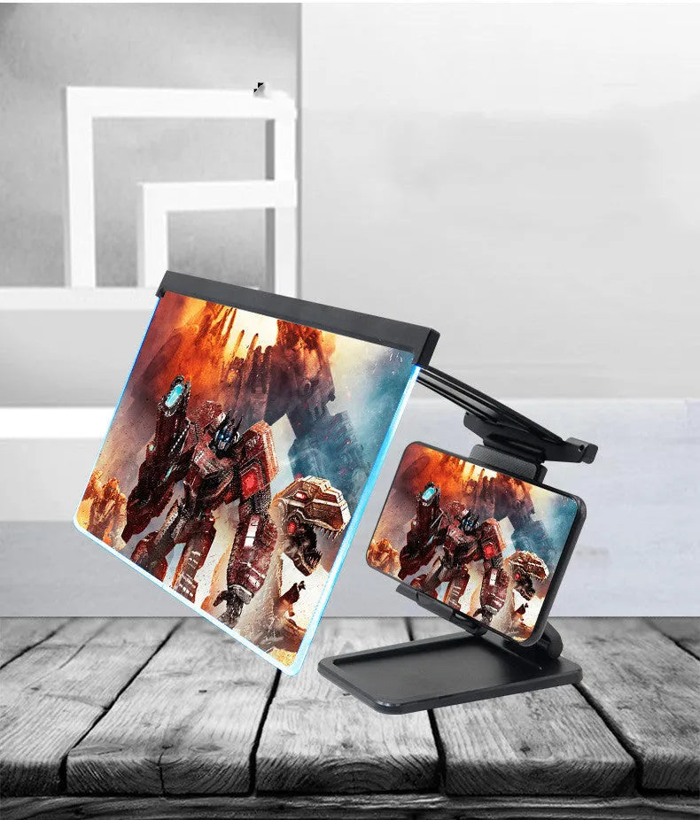 Black folding mobile phone screen amplifier with detachable holder on a desktop.