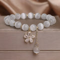 Women's white cat's eye crystal bracelet with floral tassel and morganite safety buckle pendant