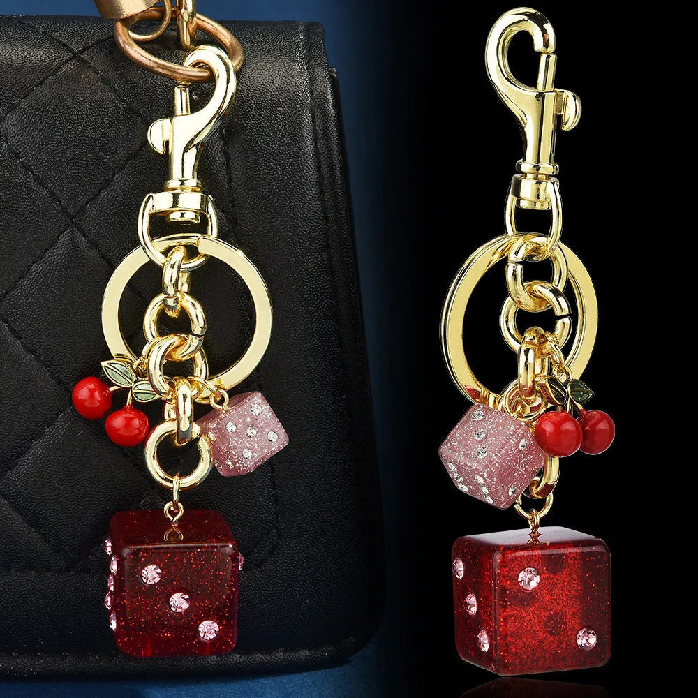Square metal keychain pendant with a vintage cherry two-tone dice pattern and electroplated finish.