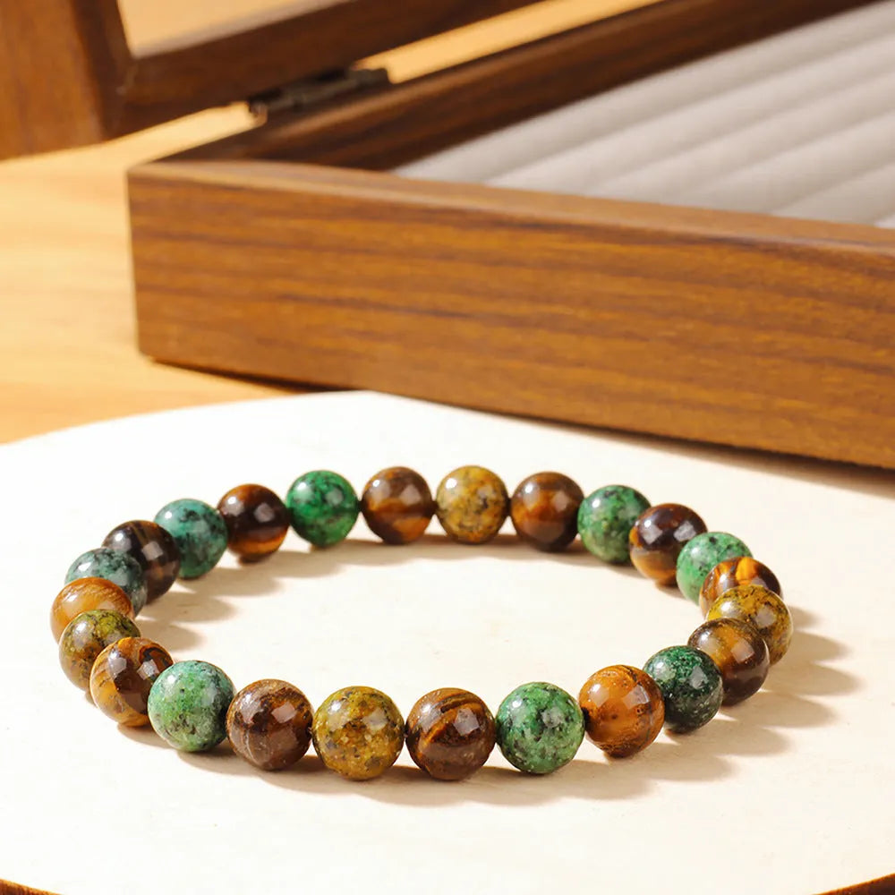 Handmade Tigereye stone bracelet with large flower-shaped bead and adjustable metal clasp on a cord.