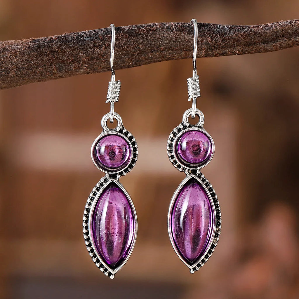 A pair of vintage-style geometric drop earrings in black and purple with a round element, bohemian jewellery.