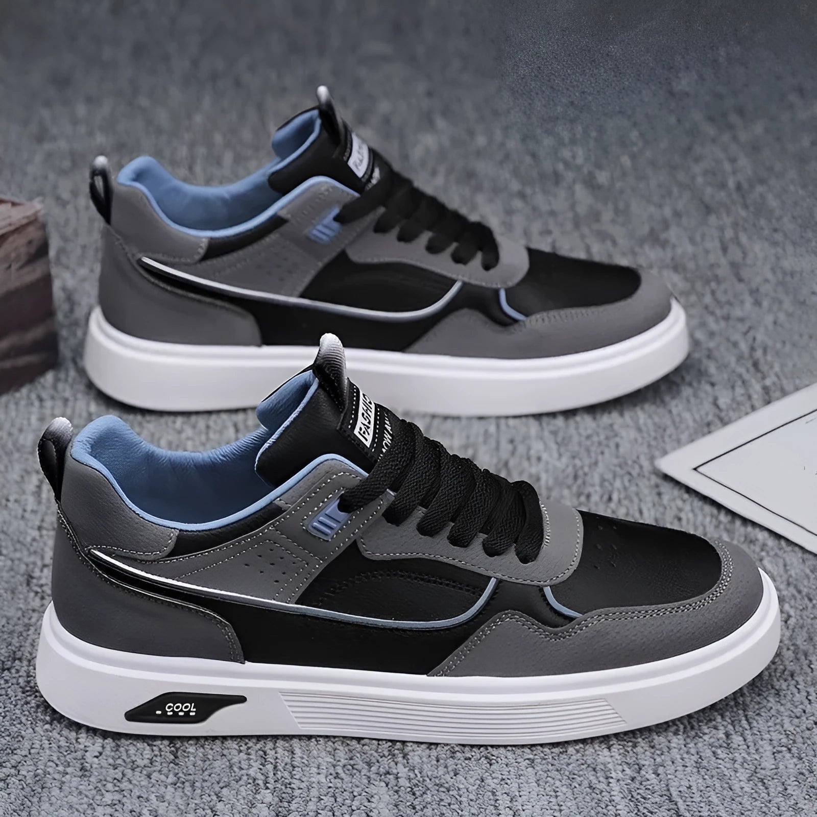 Men's low-top canvas trainers in black, beige, and grey with mesh lining and leather stitching.