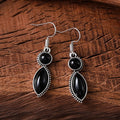 A pair of vintage-style geometric drop earrings in black and purple with a round element, bohemian jewellery.