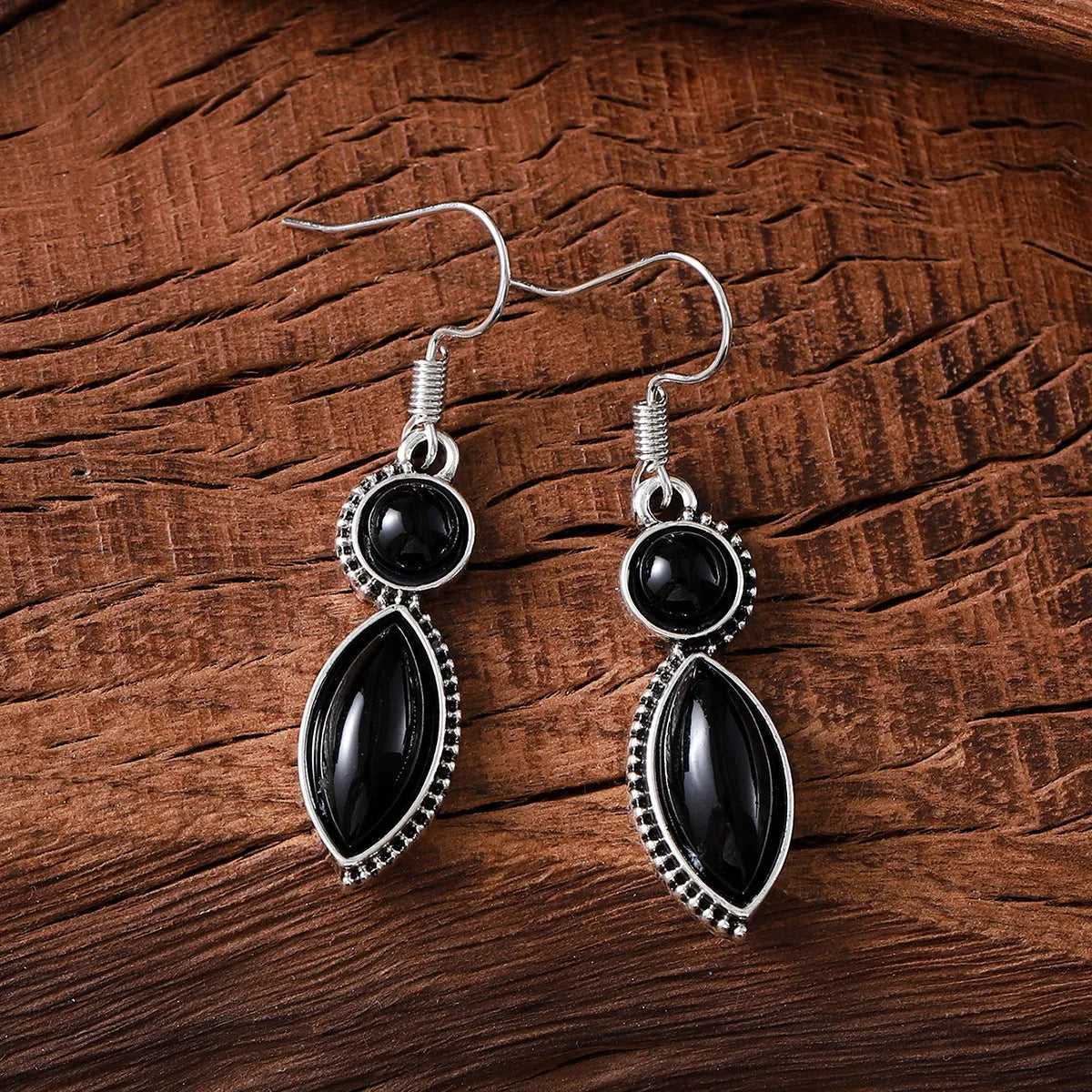 A pair of vintage-style geometric drop earrings in black and purple with a round element, bohemian jewellery.