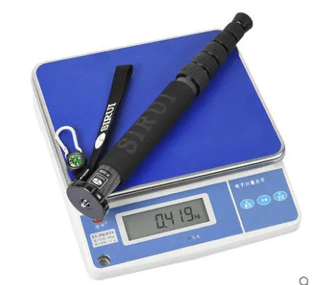 Black carbon fibre telescopic camera monopod fully extended to 1540mm next to an SLR