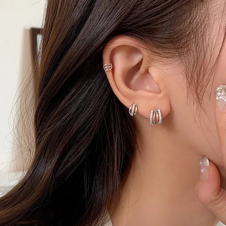 A pair of geometric-shaped 925 silver earrings with silver needle posts, shown in three available sizes.