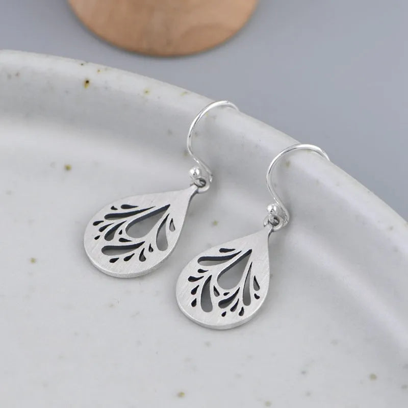 Silver hollow water drop earrings with grinding finish and retro style