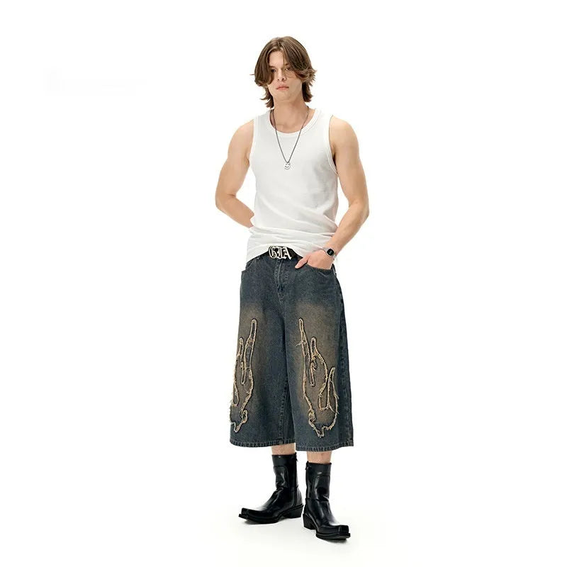 Men's black denim shorts with red flame embroidery patch on leg